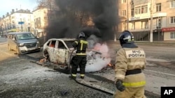 FILE - In this image from video released by the Russia Emergency Situations Ministry’s Telegram channel, Dec. 30, 2023, firefighters respond to burning cars after shelling in Belgorod, Russia. A missile attack on the city that day killed 25 and hurt 109.