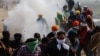 Farmers, who are marching towards New Delhi to press for better crop prices, run for cover amidst tear gas fired by police to disperse them at Shambhu barrier, a border crossing between Punjab and Haryana states, India, Feb. 21, 2024.