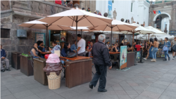 Visitantes disfrutan de ofertas gastronómicas en comercios ubicados en el centro de Quito, Ecuador. 