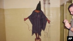 FILE - This late 2003 photo obtained by The Associated Press shows an unidentified detainee standing on a box with a bag on his head and wires tied to his body at the Abu Ghraib prison in Baghdad, Iraq.
