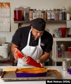 An employee at the Honduran-American Norma's Sweets Bakery in New Orleans prepares a guava cream cheese king cake during Mardi Gras 2021.