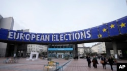 FILE - People walk under a banner advertising the European elections outside the European Parliament in Brussels, on Jan. 24, 2024. TikTok is taking measures to combat misinformation about the upcoming European Union elections.