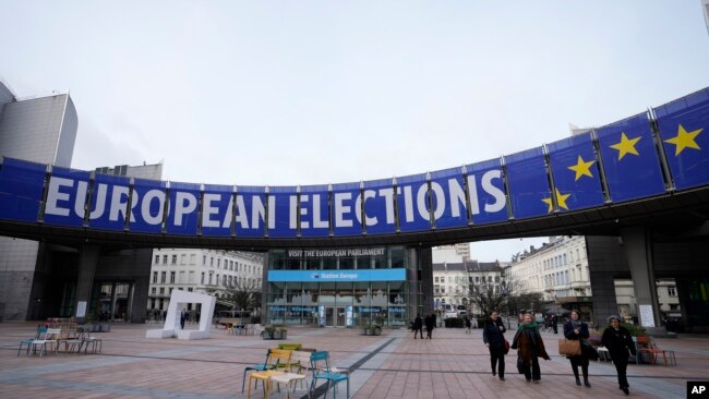 FILE - People walk under a banner advertising the European elections outside the European Parliament in Brussels, on Jan. 24, 2024. TikTok is taking measures to combat misinformation about the upcoming European Union elections.