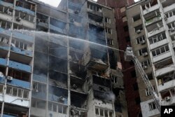 Petugas memadamkan api di sebuah gedung apartemen setelah serangan Rusia di Kyiv, Ukraina, 7 Februari 2024. Pihak berwenang mengatakan Rusia menembakkan rudal jelajah dan balistik serta drone jenis Shahed ke sasaran di seluruh Ukraina termasuk ibu kota Kyiv. (Foto: AP)