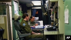 In this August 2023 photo provided by the U.S. Air Force, two missile launch officers, Lt. Sam McGlinchey, 28, front, and Lt. Joy Hawkins, 23, finish a 24-hour underground shift at a launch control center at Malmstrom Air Force Base.