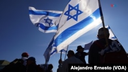 Manifestantes con banderas de Israel se congregan frente al Tribunal Supremo para reclamar que la jóvenes de la comunidad ultraortodoxa sean reclutados por el ejército.