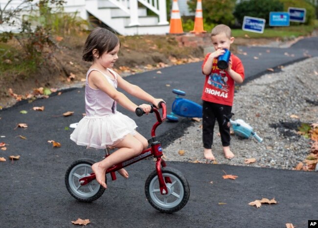 FILE - Raven Kephart (kiri) mengendarai sepeda mininya menuruni bukit kecil di Auburn, Maine, disaksikan adik laki-lakinya, Teagan, 7 Oktober 2020. (Andree Kehn/Sun Journal via AP)