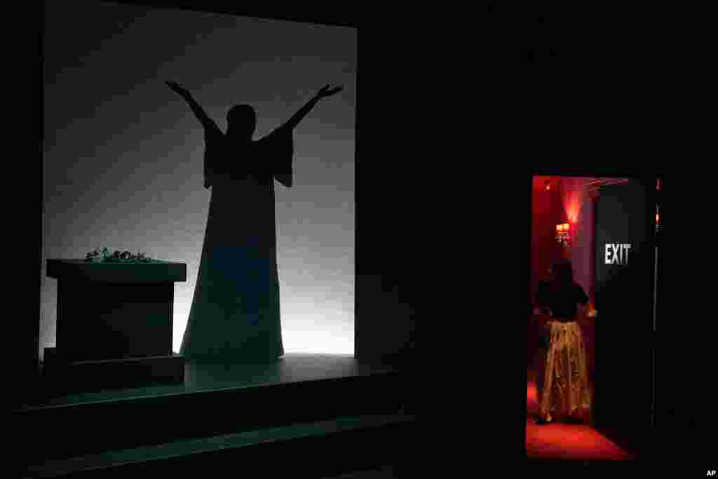 An employee opens a door as the silhouette of Greek Soprano Maria Callas is shown on screen, at the newly established Maria Callas Museum, the first dedicated to the legendary opera star, in Athens, Greece.