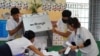 Election officials count ballots at a polling station on the day of Cambodia's general election, in Phnom Penh, Cambodia, July 23, 2023.
