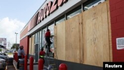 Workers board up a business to avoid damage ahead of Hurricane Beryl, in Merida, Mexico, July 3, 2024. 