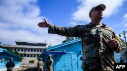 Prajurit Komando PBB (kanan) memberikan tur media di dekat garis demarkasi militer yang memisahkan Korea Utara dan Korea Selatan, di Area Keamanan Bersama (JSA) Zona Demiliterisasi (DMZ) di desa gencatan senjata Panmunjom (foto: dok). 