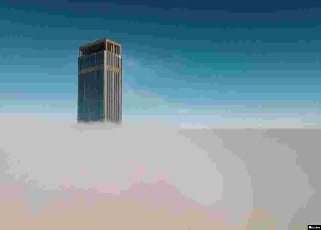 A tower of Abu Dhabi Plaza sticks out of a blanket of thick fog in Astana, Kazakhstan.