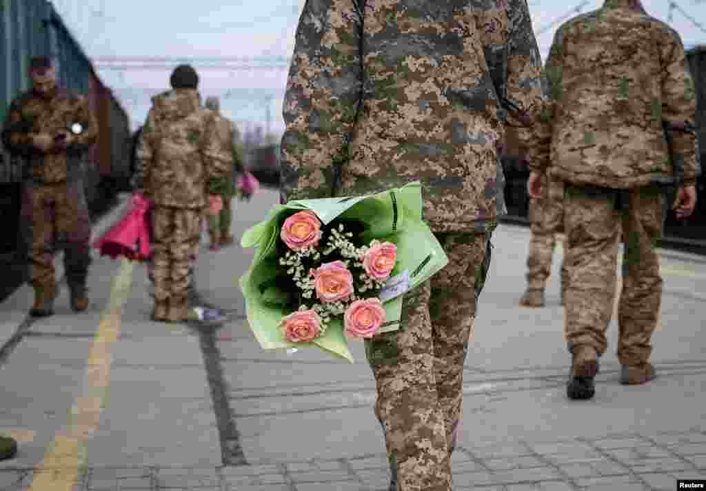Украински војници со цвеќиња, чекаат воз од Киев, на железничката станица во Краматорск.