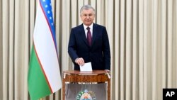 In this handout photo released by Uzbekistan's Presidential Press Office, Uzbekistan's President Shavkat Mirziyoyev casts his ballot at a polling station during a snap presidential election in Tashkent, Uzbekistan, July 9, 2023. 