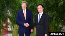 (FILE) Special Presidential Envoy for Climate John Kerry, left, shakes hands with Chinese Vice President Han Zheng.