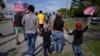 老一辈来自危地马拉的移民家族阿吉拉尔家的成员与数百人一起举着美国国旗游行，抗议佛罗里达州参议院的一项限制非法移民的法案。（2023年6月1日）