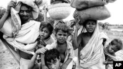 19 اپریل 1971 ایک فائل فوٹو: اس وقت کے مشرقی پاکستان کے مہاجرین کا ایک گروپ جو محفوظ مقام کی تلاش میں بھارت جارہا ہے، اے پی فوٹو