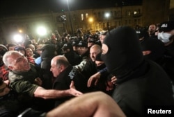 Georgian parliament member Aleko Elisashvili, left, shouts in front of law enforcement officers during a protest against a draft bill on 'foreign agents' in Tbilisi, Georgia, April 17, 2024.