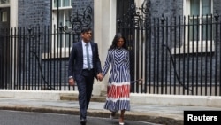 Outgoing British Prime Minister Rishi Sunak leaves Number 10 Downing Street with his wife, Akshata Murty, after delivering a speech, following the results of the elections, in London, July 5, 2024.