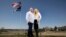 Jennifer and Tim Kohl poses for a photo in their front yard with the American flag and a thin blue line flag in Star, Idaho, on April 14, 2023. The couple recently moved to Idaho from the Los Angeles area. 