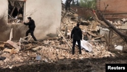 Police officers work at a site of a local museum heavily damaged by a Russian missile strike in the town of Kupiansk, Kharkiv region, Apr. 25, 2023. (Press service of the National Police of Ukraine in Kharkiv region/Handout via Reuters) 