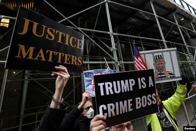Para pengunjuk rasa berdiri di luar kantor Kejaksaan Distrik Manhattan saat penyelidikan tentang suap Donald Trump sebesar $130.000 yang dilakukan sebelum Pilpres 2016 kepada seorang bintang porno. (Foto: Reuters)