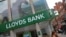 FILE - Women walk past a branch of Lloyds bank in London, Britain, July 20, 2018. 