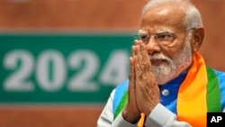 Indian Prime Minister Narendra Modi greets during the unveiling of his Hindu nationalist Bharatiya Janata party’s election manifesto in New Delhi, India, April 14, 2024.