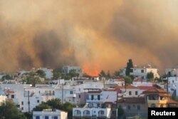 Vatra i dim dižu se nedaleko od sela Genadi, na islandu Rodos, Grčka, 25. jula 2023.