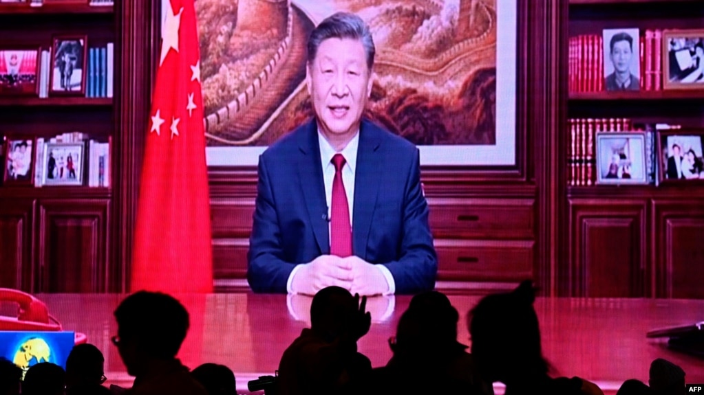 2023 年 12 月 31 日，人们在一家餐厅吃晚饭，屏幕上播放着中国国家主席习近平在北京发表新年讲话的画面。(法新社)(photo:VOA)