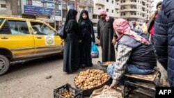 FILE - A truffle vendor speaks to customers at a market in Raqa, Syria, March 14, 2023. Fourteen truffle hunters were reportedly killed Sunday by an unexploded mine in the Raqa desert.