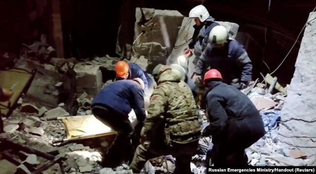 Emergency responders retrieve bodies from the rubble of a damaged building following a Ukrainian attack in a location given as Lysychansk in the occupied eastern Ukrainian region of Luhansk, in this screen grab obtained from a video released, Feb. 3, 2024.