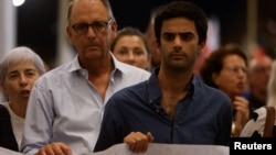 Peter Caruana Galizia, left, widower of late anti-corruption journalist Daphne Caruana Galizia, and their son Paul Caruana Galizia take part in a protest march on the sixth anniversary of her assassination, in Valletta, Malta, Oct. 16, 2023.