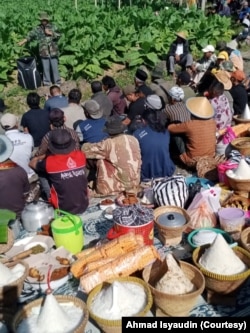 Petani menikmati sajian di tengah acara wiwit mbako di Desa Tlahab, Temanggung, Jawa Tengah. (Foto: Courtesy/Ahmad Isyaudin)