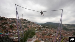 FILE - A tourist bungee jumps in the Comuna 13 neighborhood of Medellin, Colombia, Feb. 2, 2024.
