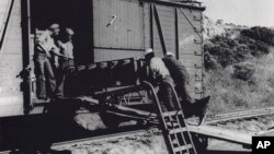 FILE - Black sailors of a naval ordnance battalion unload aerial bombs from a rail car, circa 1943/44, in Port Chicago, California, in this image provided by Naval History and Heritage Command.