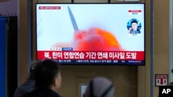 FILE - A TV screen shows a file photo of a North Korean missile launch during a news program, at the Seoul Railway Station in Seoul, South Korea, March 22, 2023. 
