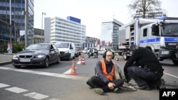 Police remove an activist of the environmental group 'Last Generation' (Letzte Generation) sitting on the ground to cause a traffic jam near Berlin's Ernst-Reuter-Platz central place during a climate action in Berlin, Germany, April 24, 2023.