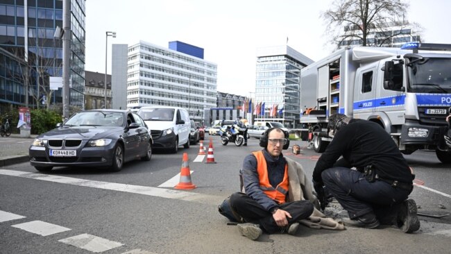 Police remove an activist of the environmental group 'Last Generation' (Letzte Generation) sitting on the ground to cause a traffic jam near Berlin's Ernst-Reuter-Platz central place during a climate action in Berlin, Germany, April 24, 2023.