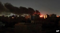 Smoke rises over the horizon as a fire burns after a strike in Khartoum, Sudan, April 16, 2023.