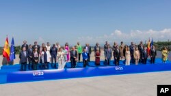 EU Commission President Ursula von der Leyen and Spain's Prime Minister Pedro Sánchez, center and foreground, pose for a family picture with members of the Spanish government and EU commissioners before the start of an EU summit in Madrid, July 3, 2023. 