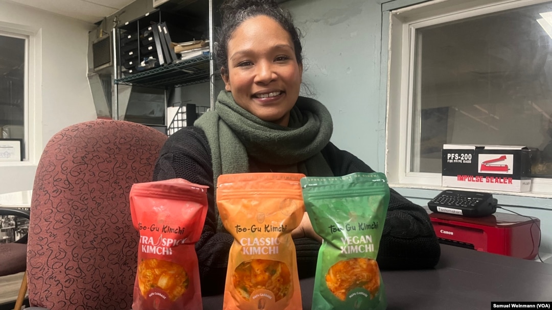 Patrice Cunningham, founder and CEO of Tae-Gu Kimchi, poses in her Washington office with three bags of the kimchi she makes and distributes with her mother, Jan. 24, 2024.