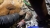 People work to rescue a Palestinian girl, who is alive, from under the rubble of a house hit by an Israeli strike, amid the ongoing conflict between Israel and the Palestinian Islamist group Hamas, in Rafah in the southern Gaza Strip.