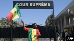  Manifestante senegalês segura a bandeira nacional em frente ao Supremo Tribunal.