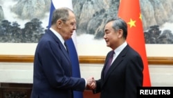 Menteri Luar Negeri Rusia Sergei Lavrov berjabat tangan dengan Menteri Luar Negeri China Wang Yi saat pertemuan di Beijing, China, 9 April 2024. (Kementerian Luar Negeri Rusia/Handout via REUTERS)