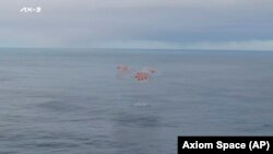 This photo provided by Axiom Space shows a SpaceX capsule parachuting into the Atlantic Ocean off the Florida coast, Feb. 9, 2024. The astronauts were returning to Earth after a mission at the International Space Station.
