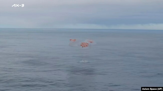 This photo provided by Axiom Space shows a SpaceX capsule parachuting into the Atlantic Ocean off the Florida coast, Feb. 9, 2024. The astronauts were returning to Earth after a mission at the International Space Station.