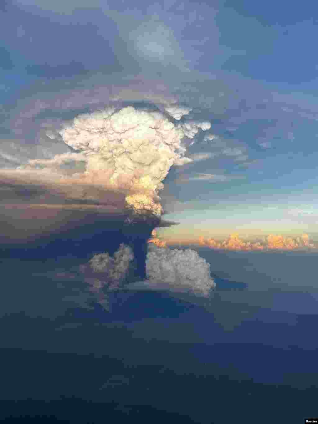 Ash column rises from Mount Ulawun, as seen from an airplane window, Papua New Guinea, in this picture obtained from social media. (Enoch Lapa/via Reuters)