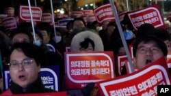한국 정부의 의대 입학 정원 확대 계획에 반발하는 의사들이 22일 서울 시내에서 시위하고 있다. 