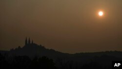 A haze is seen as the sun sets over the Holy Hill Basilica and National Shrine of Mary Tuesday, June 27, 2023, in Hubertus, Wis., northwest of Milwaukee